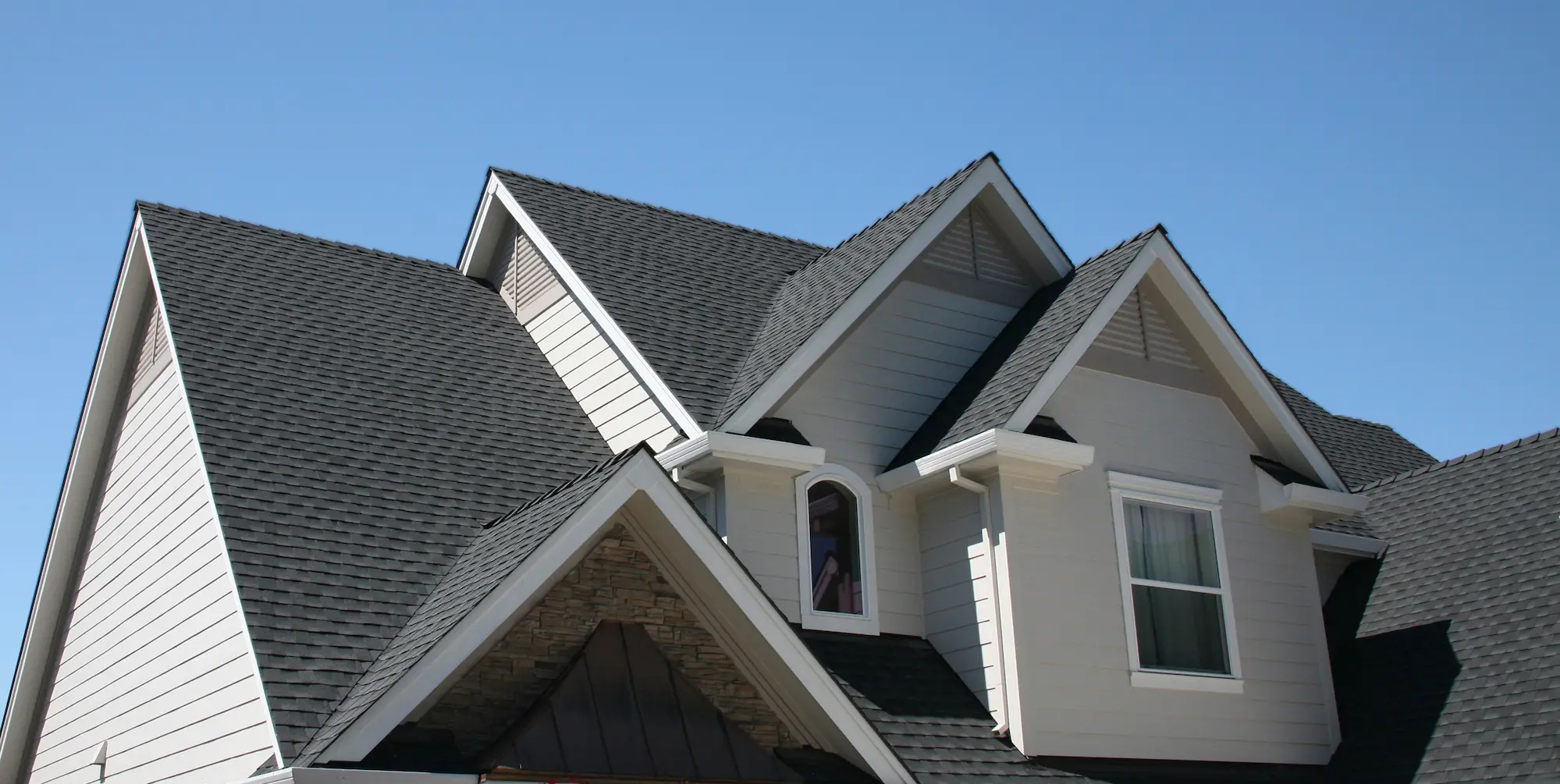 Grey roofing shingles on asphalt roof system.